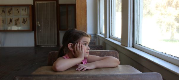 Child in school staring out the window